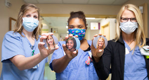 Nurses holding photo buttons wearing masks